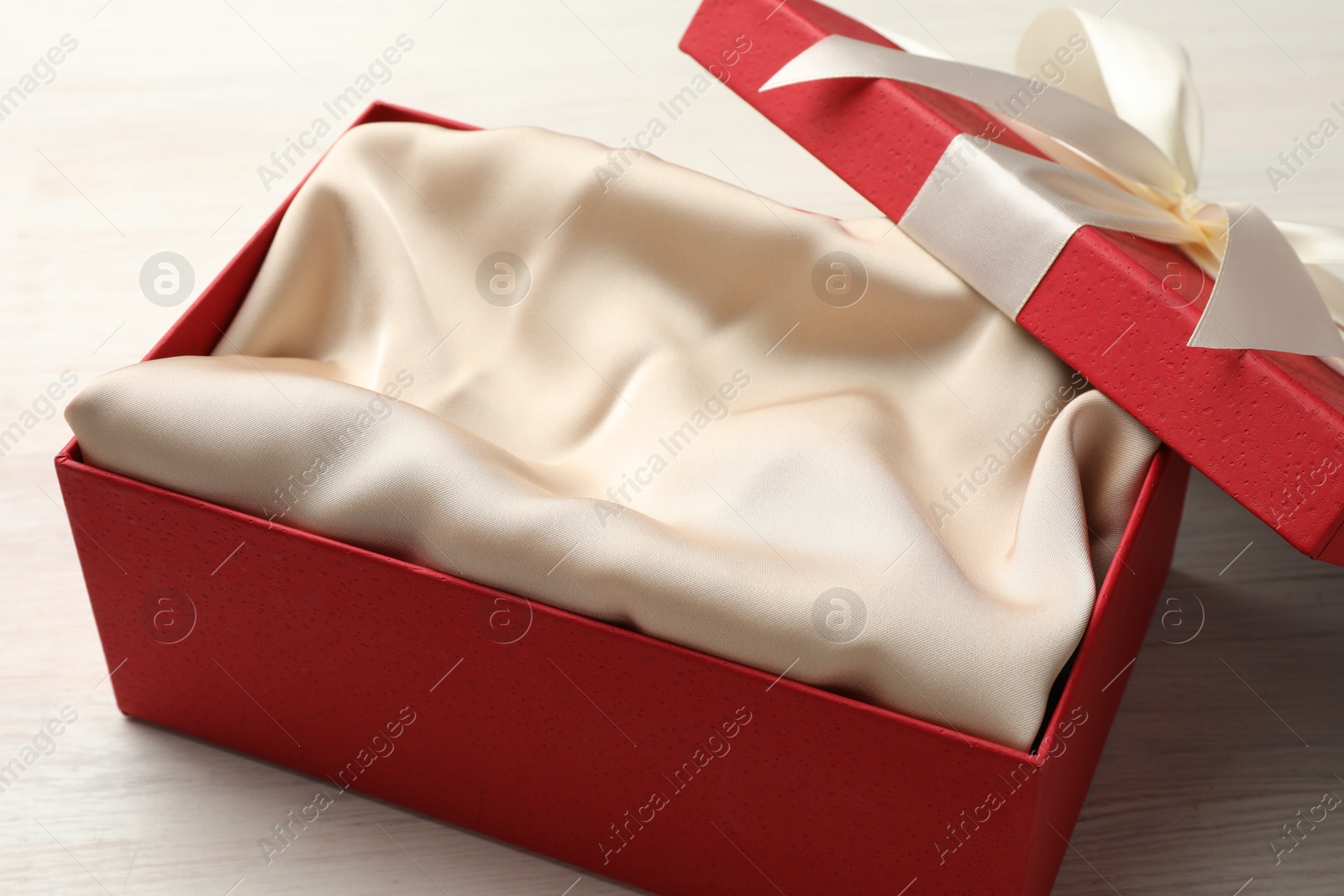 Photo of Open gift box with beautiful lid on white wooden table, closeup