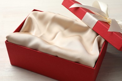 Photo of Open gift box with beautiful lid on white wooden table, closeup