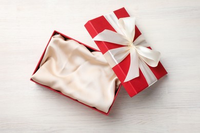 Photo of Open gift box with beautiful lid on white wooden table, top view