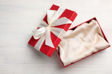 Photo of Open gift box with beautiful lid on white wooden table, top view