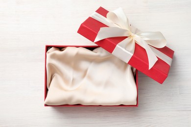Photo of Open gift box with beautiful lid on white wooden table, top view