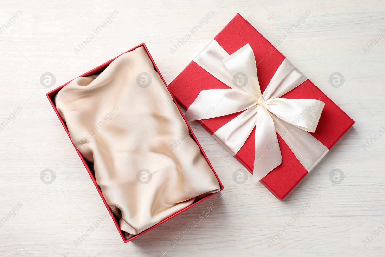 Photo of Open gift box with beautiful lid on white wooden table, top view