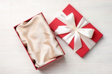 Photo of Open gift box with beautiful lid on white wooden table, top view