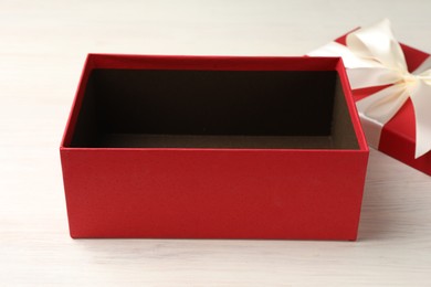 Photo of Open gift box with beautiful lid on white wooden table