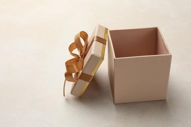 Photo of Open gift box with beautiful lid on light background, space for text