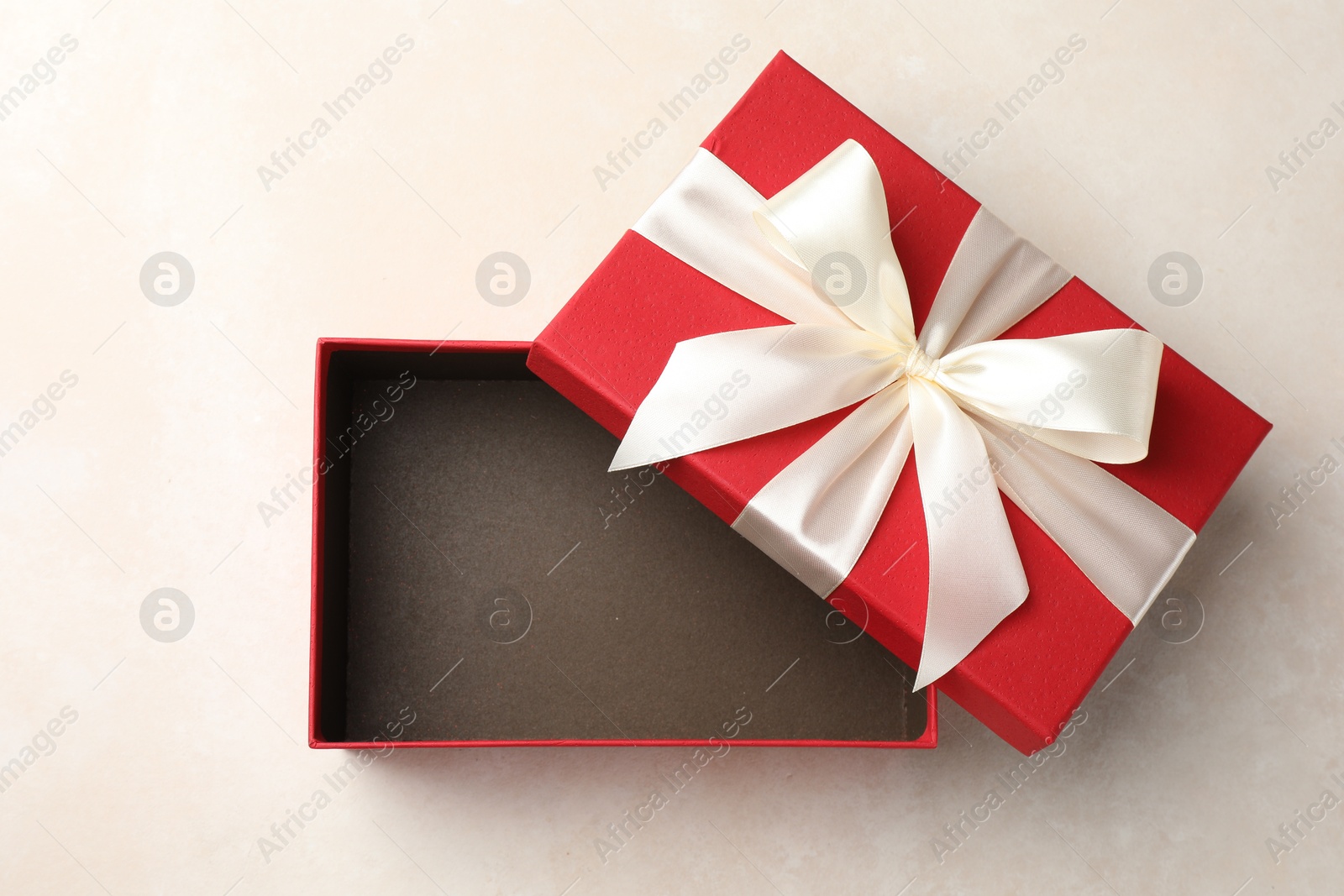 Photo of Open gift box with beautiful lid on light background, top view