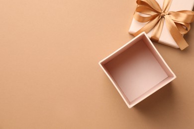Photo of Opened gift box with beautiful lid on beige background, top view. Space for text