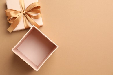 Photo of Opened gift box with beautiful lid on beige background, top view. Space for text