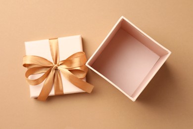 Photo of Opened gift box with beautiful lid on beige background, top view
