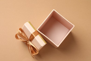 Photo of Opened gift box with beautiful lid on beige background, top view