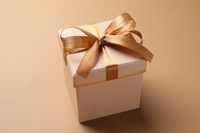 Photo of Gift box with beautiful bow on beige background, closeup