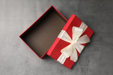 Photo of Opened gift box with beautiful lid on grey table, top view