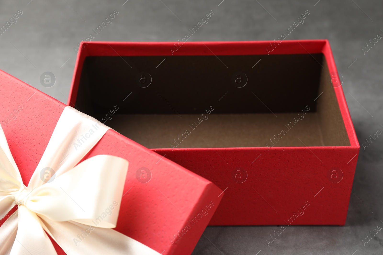 Opened gift box with beautiful lid on grey table, closeup Photo of Opened gift box with beautiful lid on grey table, closeup