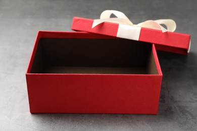 Photo of Opened gift box with beautiful lid on grey table, closeup
