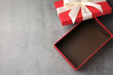Photo of Opened gift box with beautiful lid on grey table, top view. Space for text