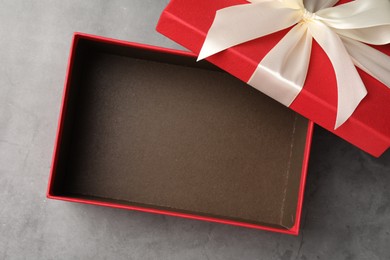 Photo of Opened gift box with beautiful lid on grey table, top view