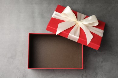Photo of Opened gift box with beautiful lid on grey table, top view