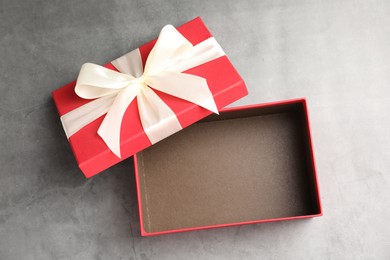 Photo of Opened gift box with beautiful lid on grey table, top view