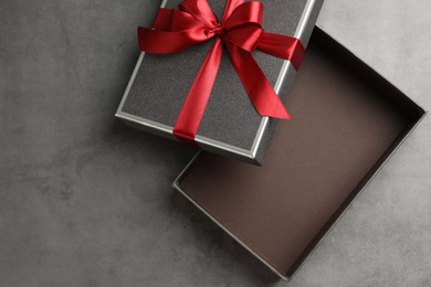 Photo of Opened gift box with beautiful lid on grey table, top view