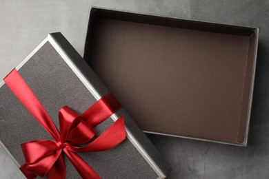 Photo of Opened gift box with beautiful lid on grey table, top view