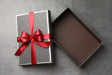Photo of Opened gift box with beautiful lid on grey table, top view