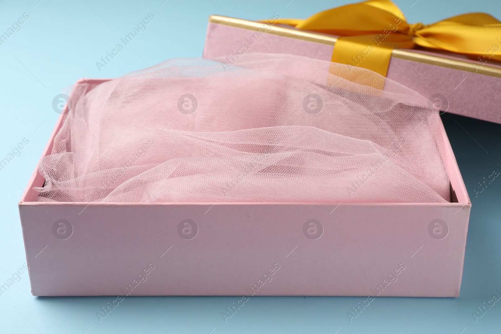Opened gift box with beautiful lid on light blue background, closeup Photo of Opened gift box with beautiful lid on light blue background, closeup