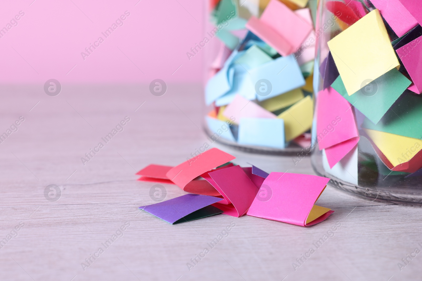 Message notes. Colorful paper pieces in glass jars on wooden table, closeup. Space for text Photo of Message notes. Colorful paper pieces in glass jars on wooden table, closeup. Space for text
