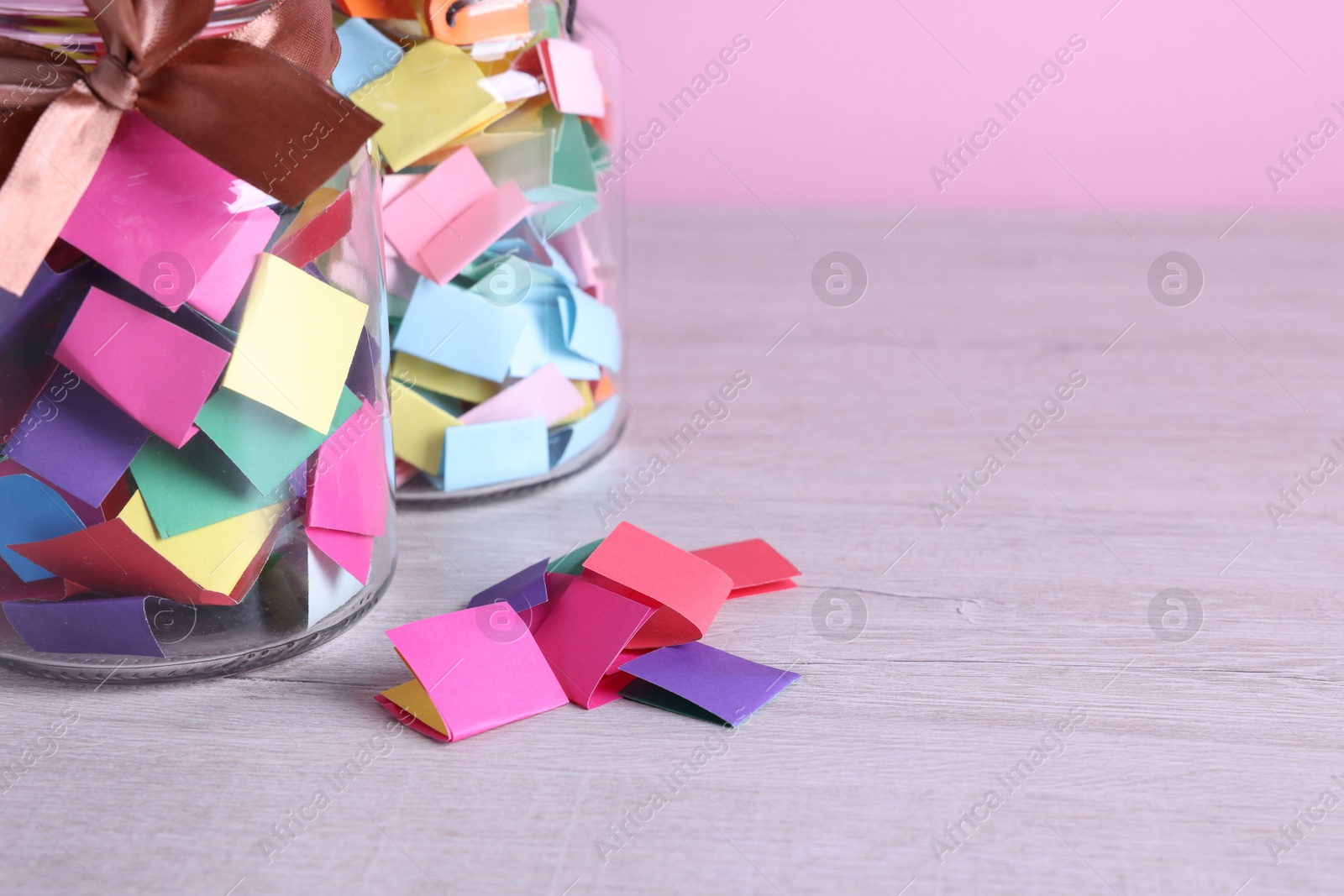 Message notes. Colorful paper pieces and glass jars on wooden table, closeup. Space for text Photo of Message notes. Colorful paper pieces and glass jars on wooden table, closeup. Space for text