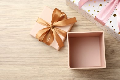 Photo of Opened and closed gift boxes on light wooden table, flat lay. Space for text