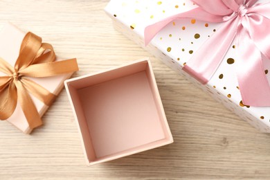 Photo of Opened and closed gift boxes on light wooden table, flat lay