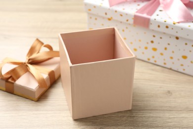 Photo of Opened and closed gift boxes on light wooden table, closeup