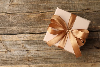 Photo of Gift box with beautiful bow on wooden table, top view. Space for text