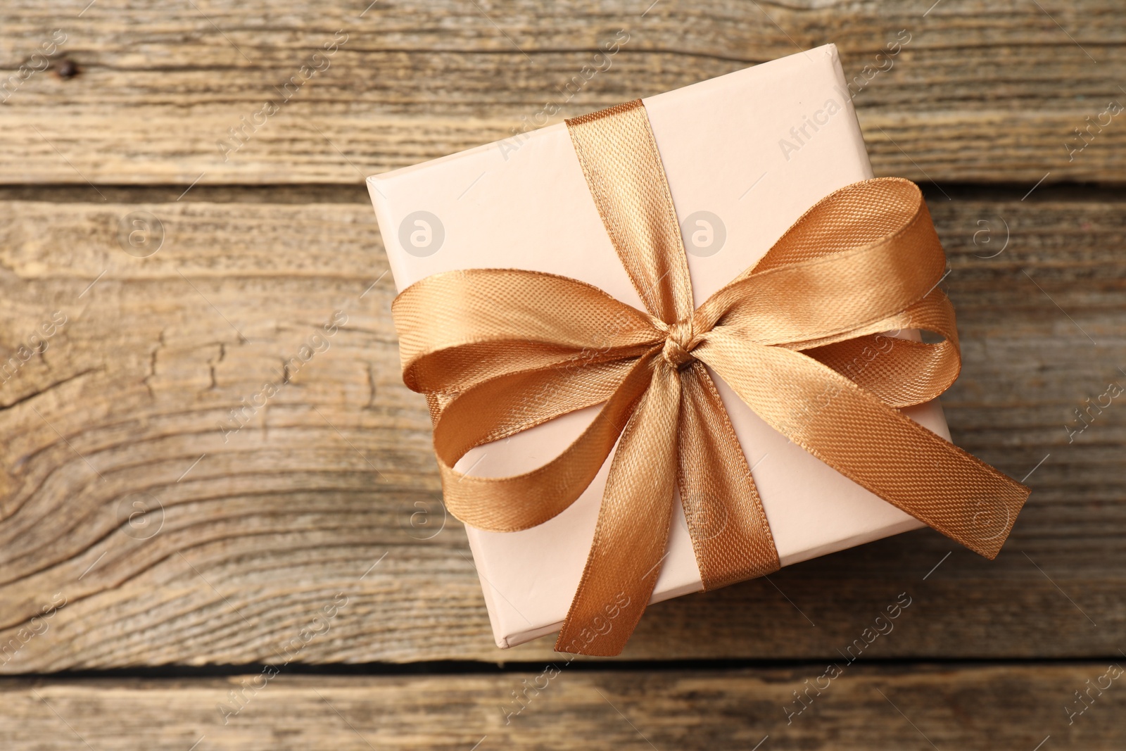 Photo of Gift box with beautiful bow on wooden table, top view. Space for text