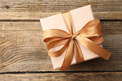 Photo of Gift box with beautiful bow on wooden table, top view. Space for text