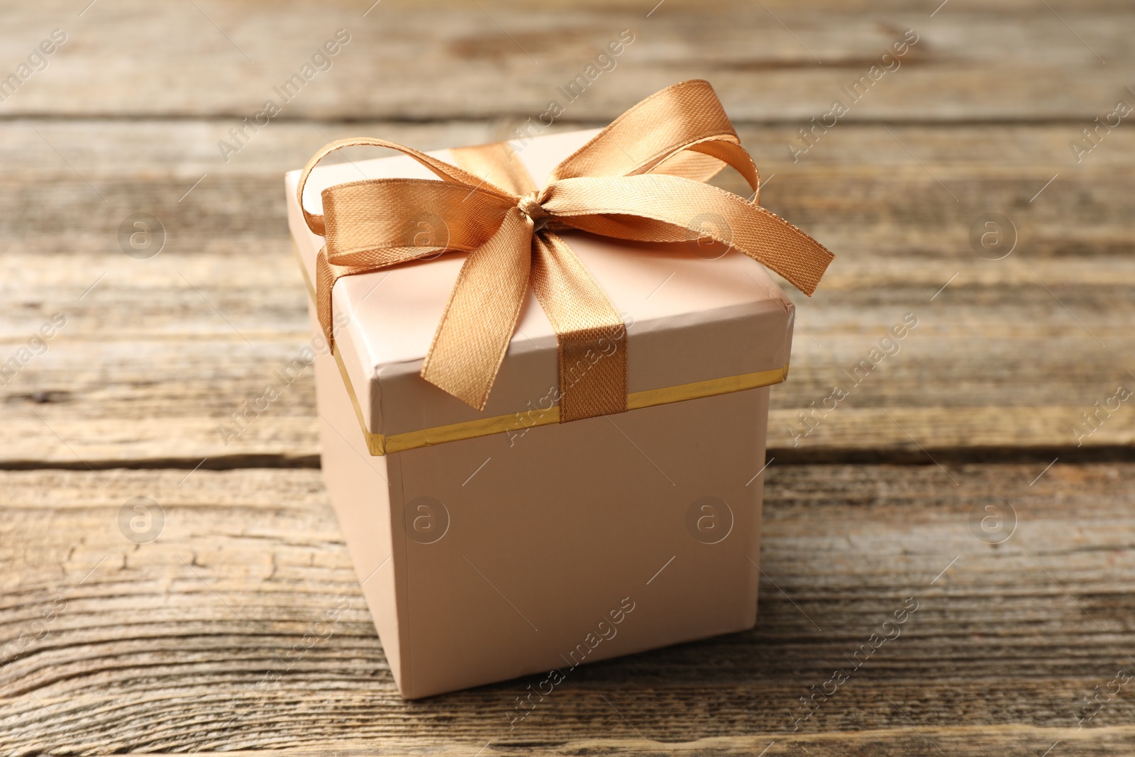 Gift box with beautiful bow on wooden table, closeup Photo of Gift box with beautiful bow on wooden table, closeup