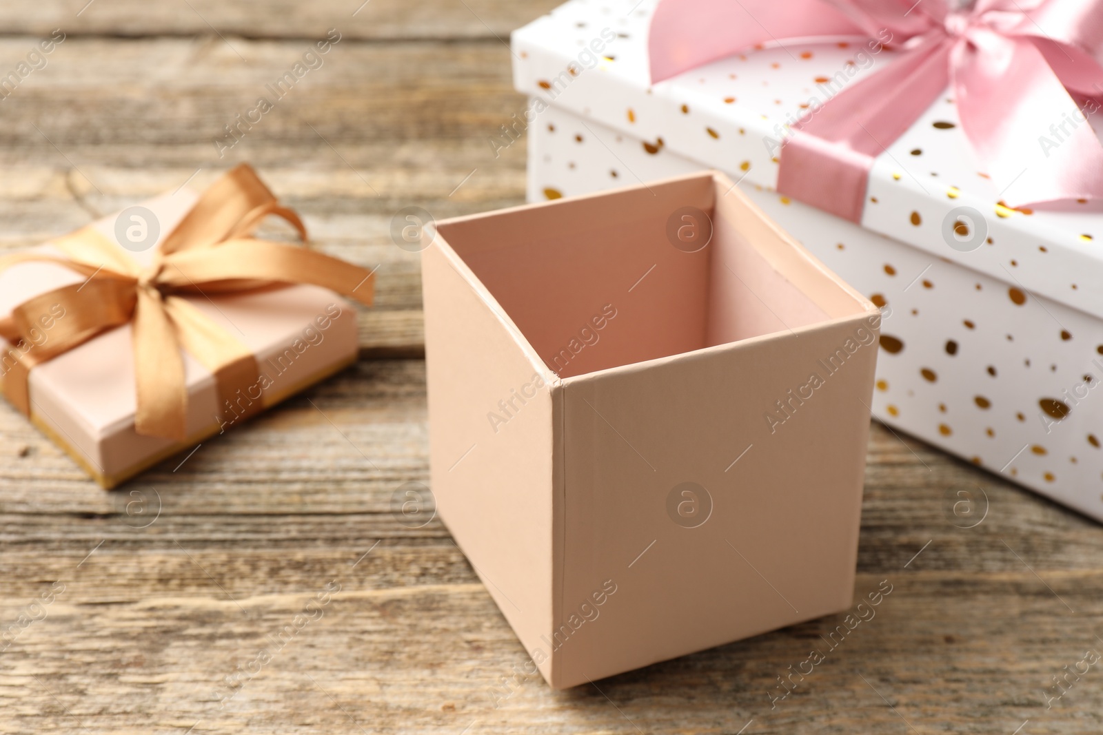 Photo of Opened and closed gift boxes on wooden table, closeup