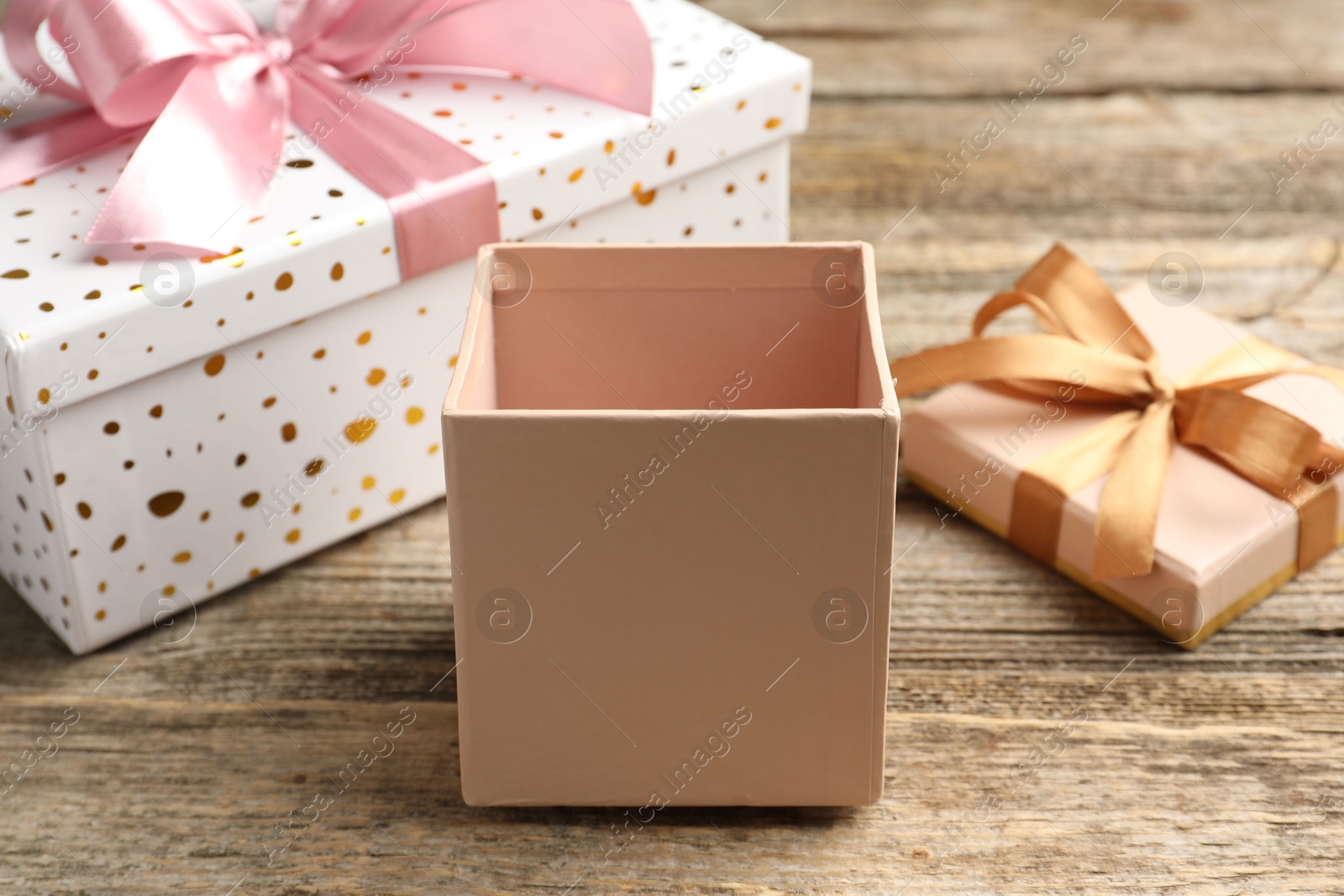 Opened and closed gift boxes on wooden table, closeup Photo of Opened and closed gift boxes on wooden table, closeup