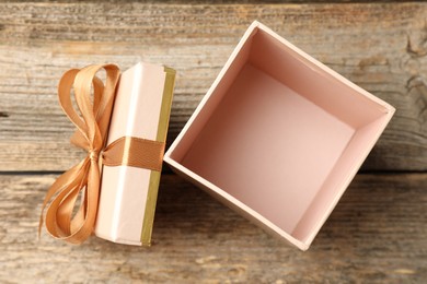 Photo of Opened gift box with beautiful lid on wooden table, top view