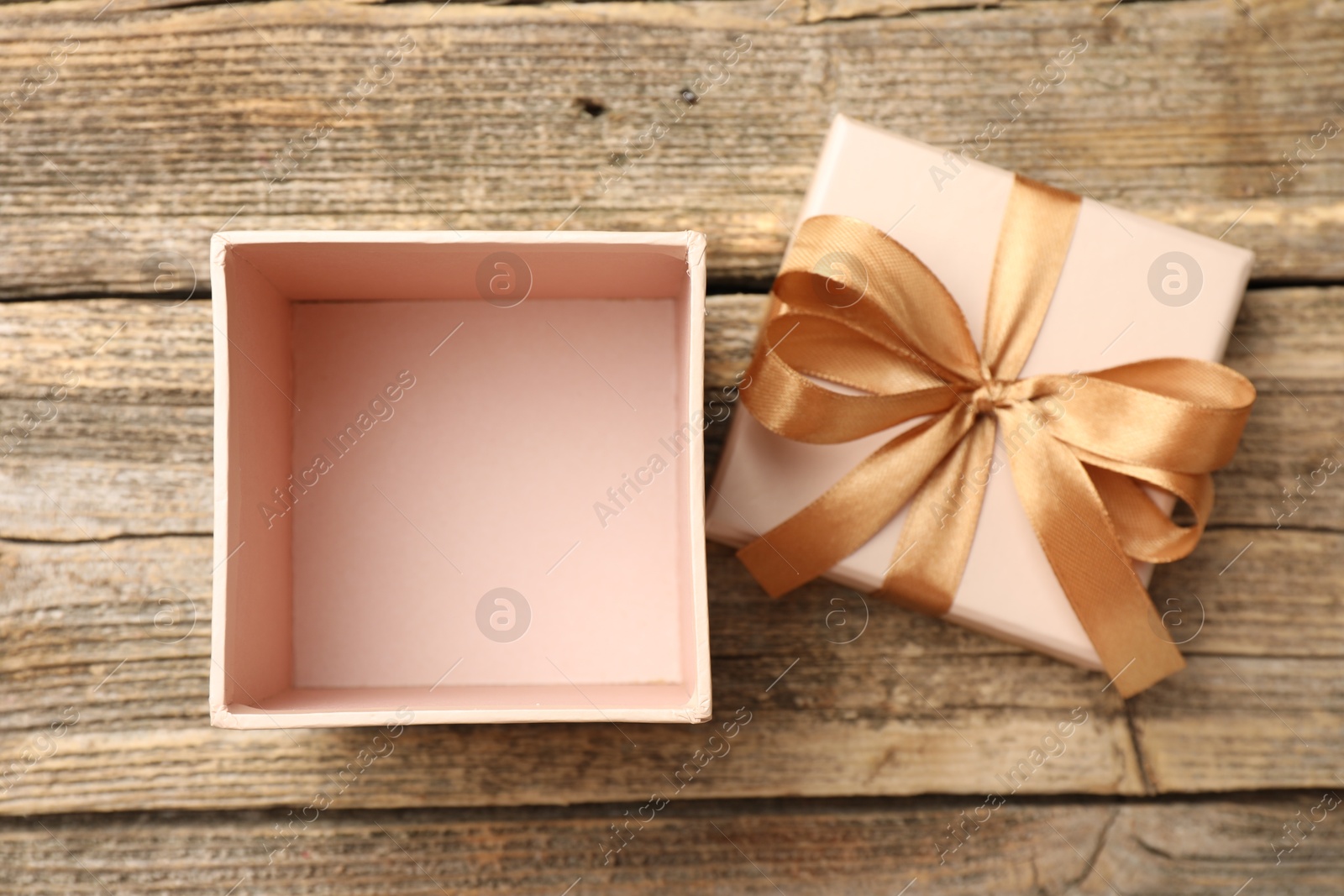 Photo of Opened gift box with beautiful lid on wooden table, top view