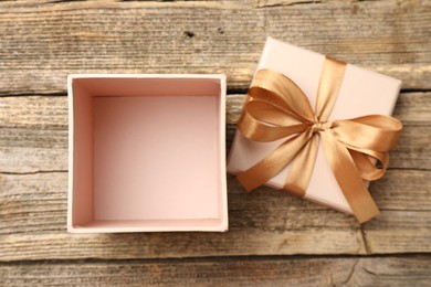 Photo of Opened gift box with beautiful lid on wooden table, top view