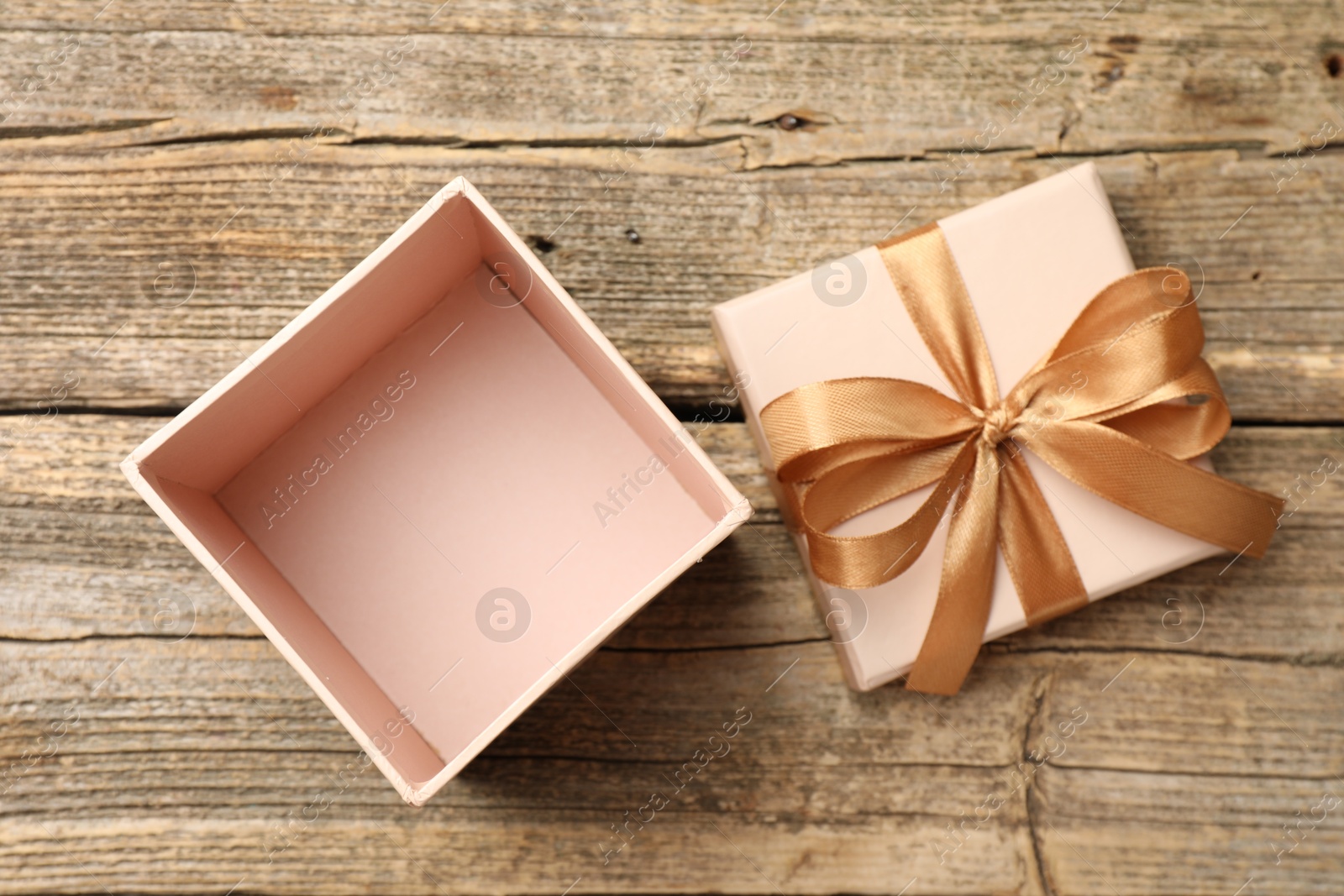 Photo of Opened gift box with beautiful lid on wooden table, top view