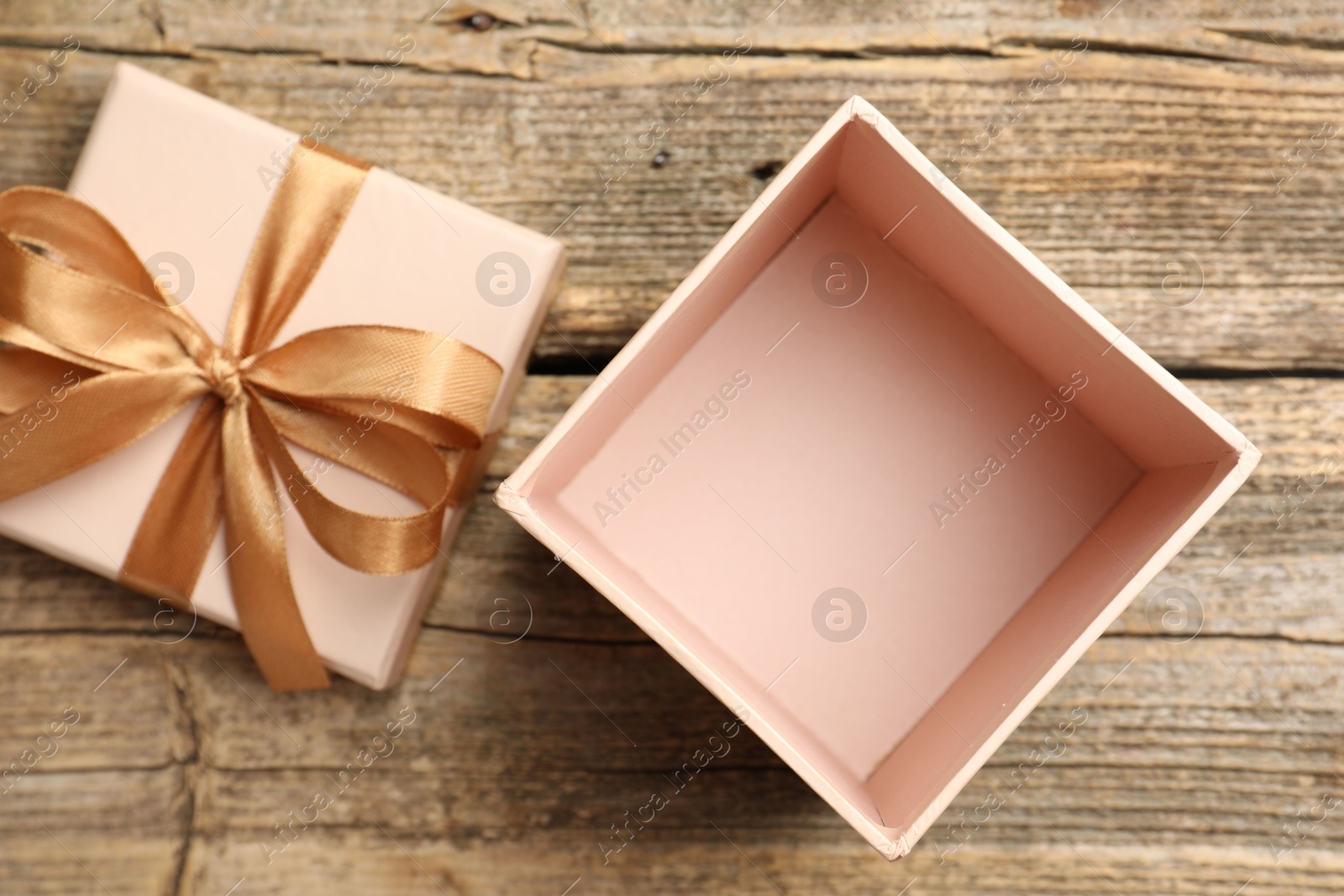 Photo of Opened gift box with beautiful lid on wooden table, top view