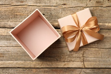 Photo of Opened gift box with beautiful lid on wooden table, top view