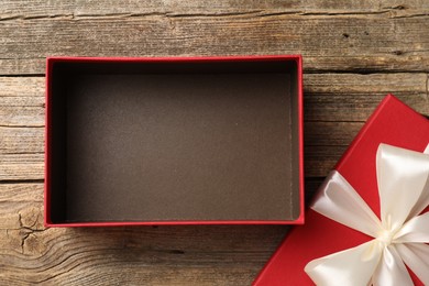 Photo of Opened gift box with beautiful lid on wooden table, top view