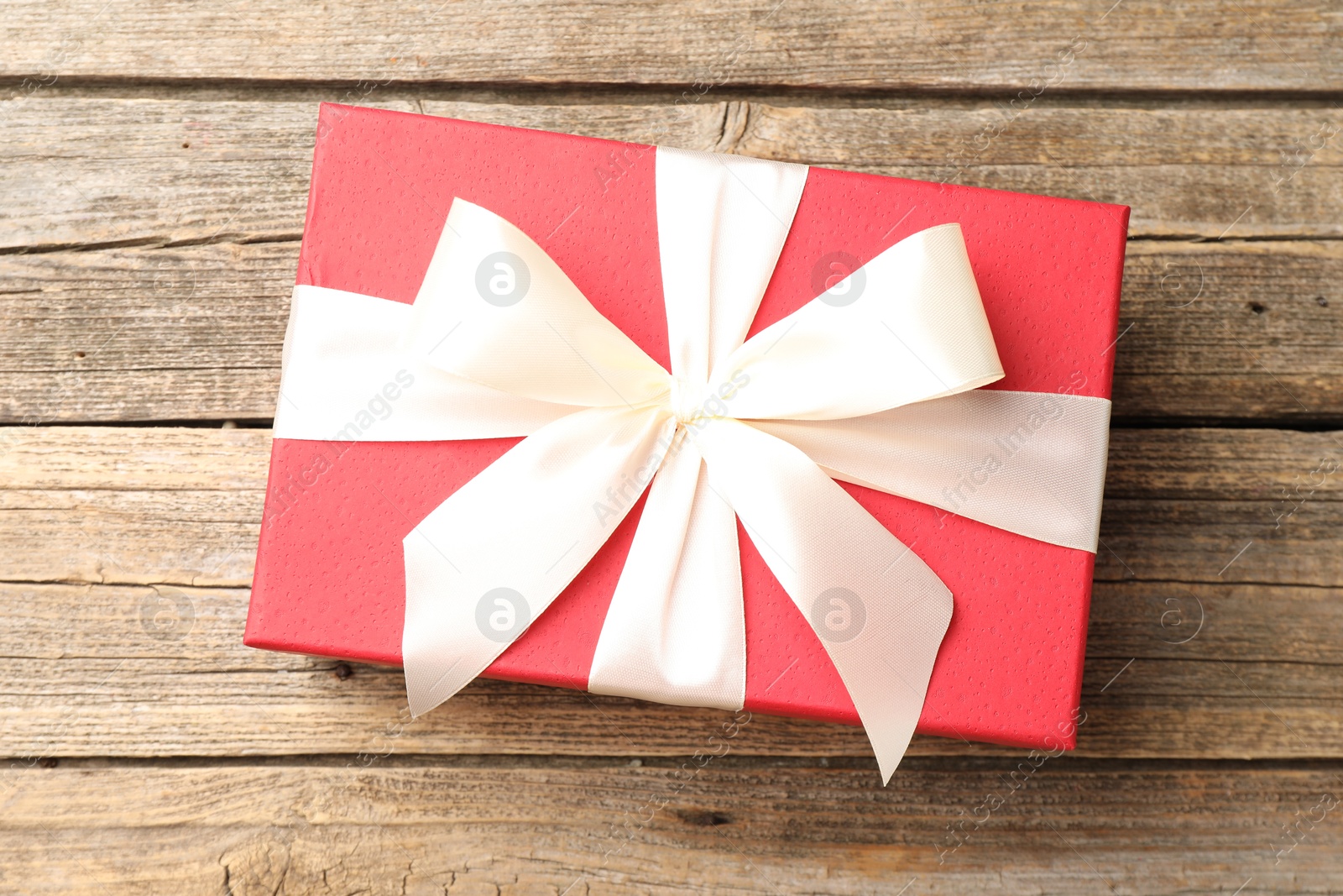 Photo of Gift box with beautiful bow on wooden table, top view