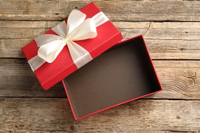 Photo of Opened gift box with beautiful lid on wooden table, top view