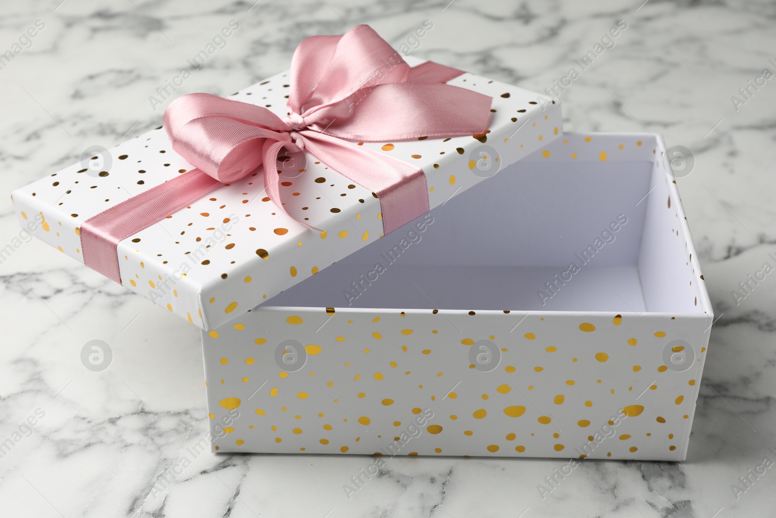 Opened gift box with beautiful lid on white marble table, closeup Photo of Opened gift box with beautiful lid on white marble table, closeup