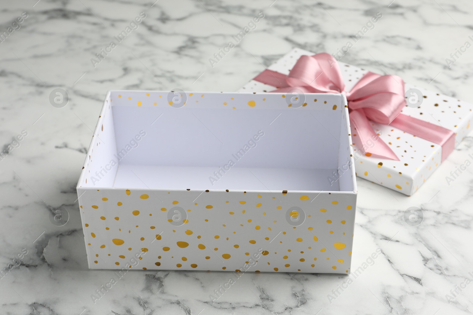 Opened gift box with beautiful lid on white marble table, closeup Photo of Opened gift box with beautiful lid on white marble table, closeup