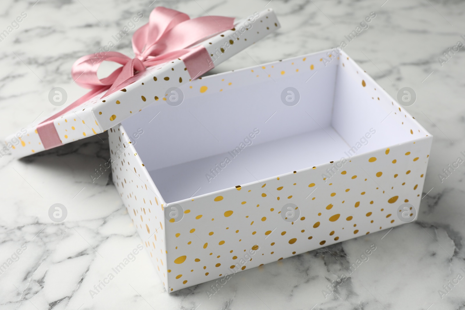 Opened gift box with beautiful lid on white marble table, closeup Photo of Opened gift box with beautiful lid on white marble table, closeup