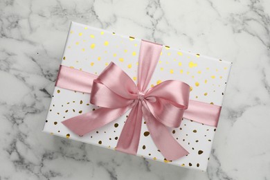 Photo of Gift box with beautiful bow on white marble table, top view